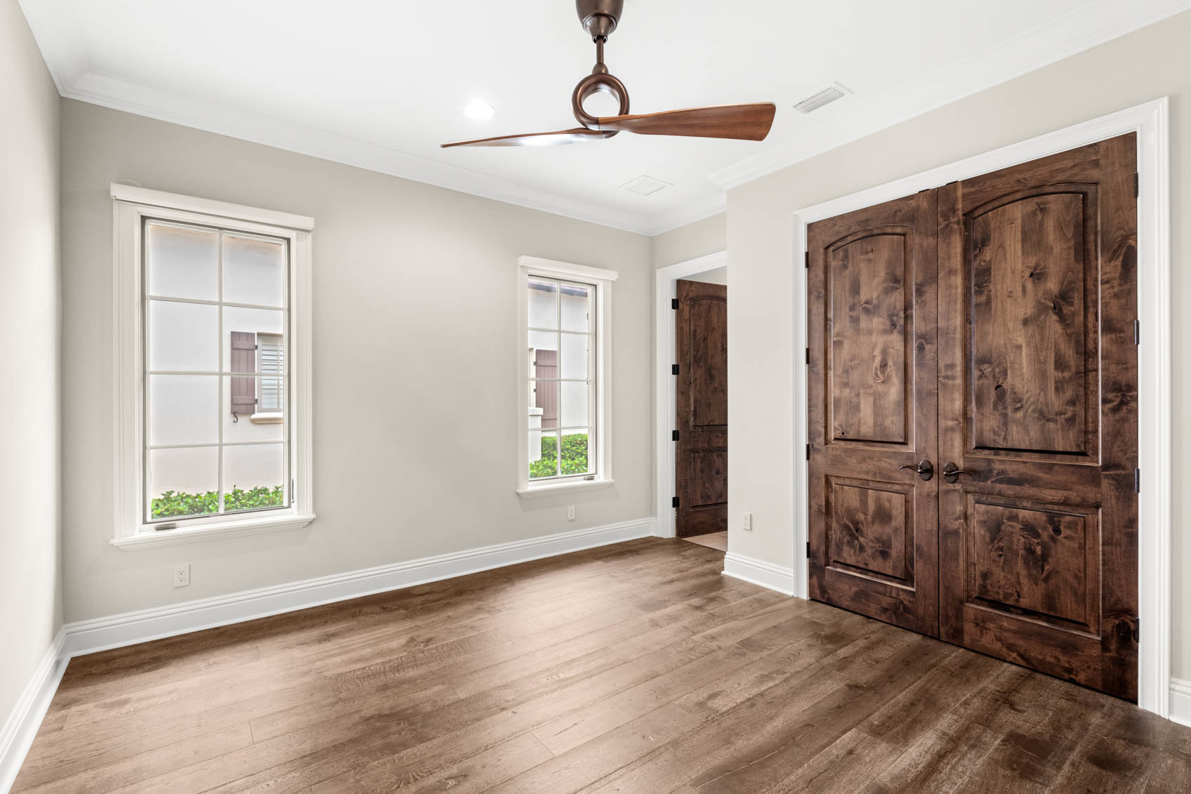 empty bedroom with wood floors and windows